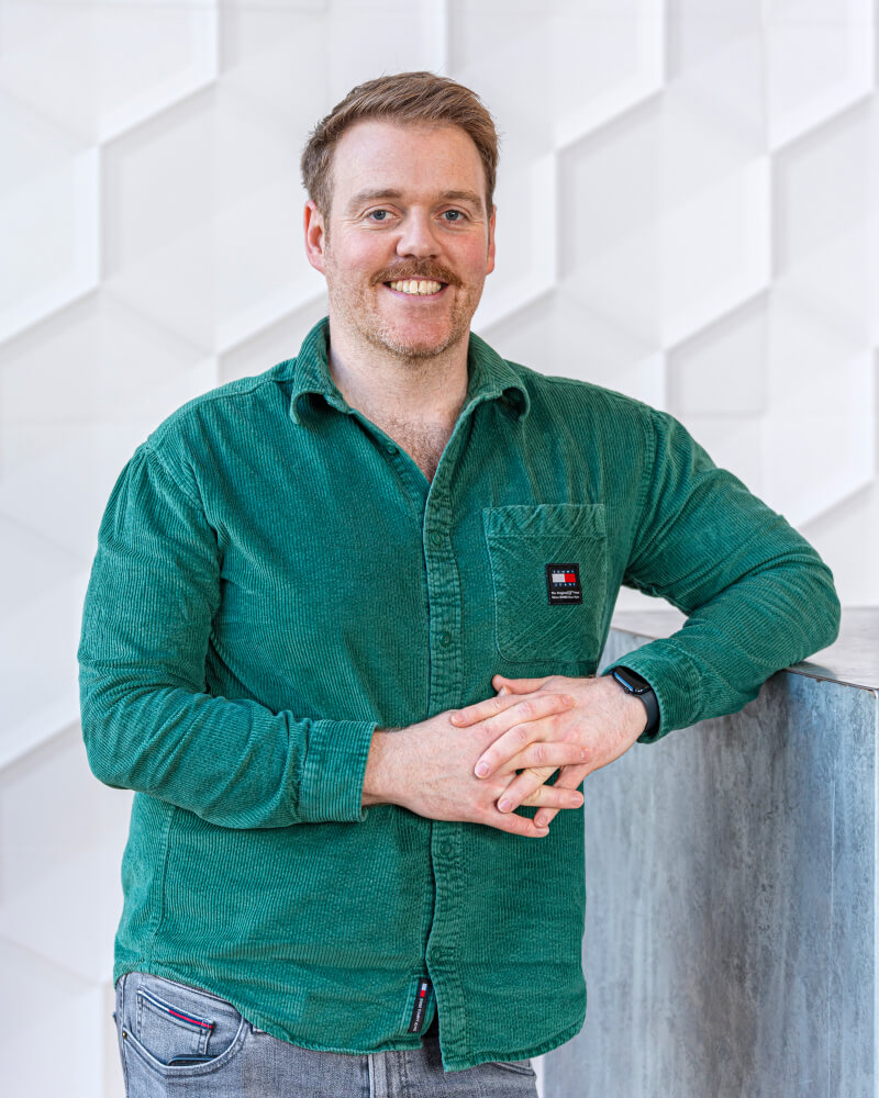 Paul Howell facing the camera in a green shirt